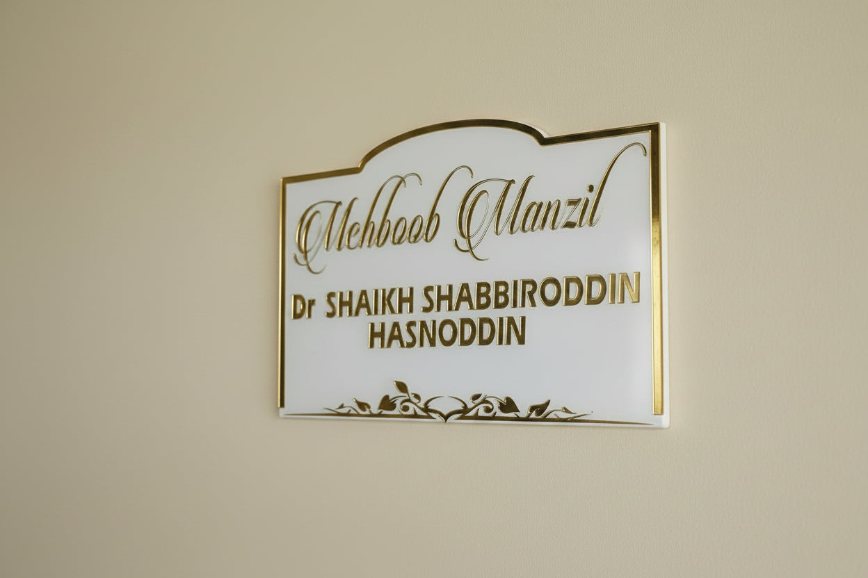 Decorative nameplate with gold text held by a hand against a plain background